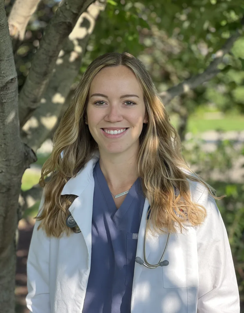 Dr. Morgan Murray standing in front of a tree wearing a white lab coat
